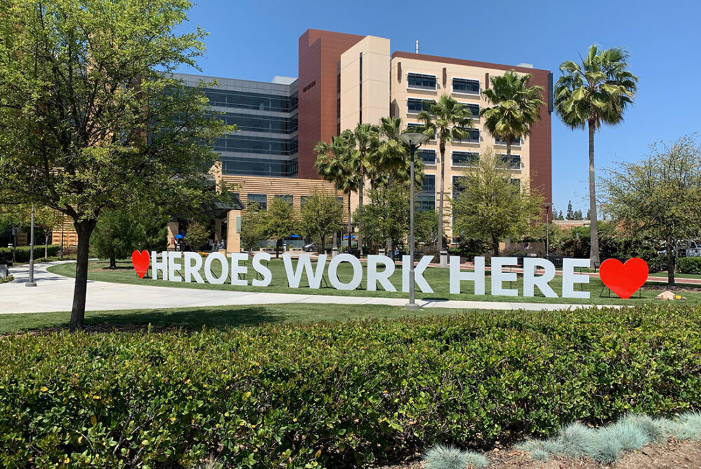 Signage in front of UC Irvine Health hospital: heroes work here