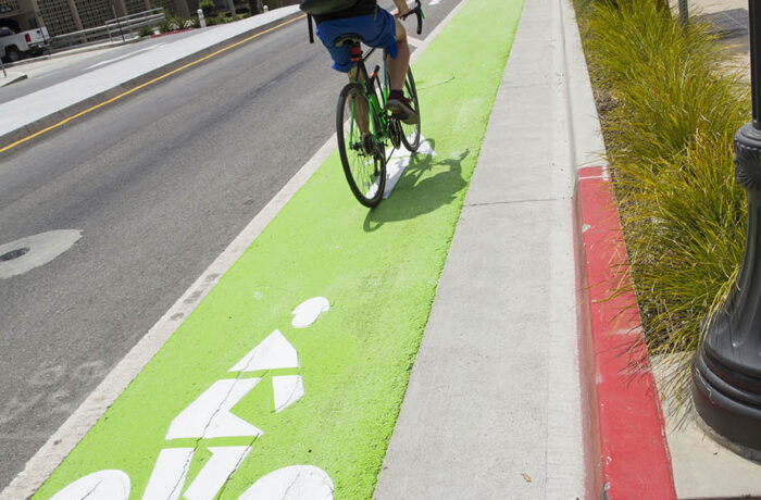 Student commuting by bike in a bike lane painted green at UCLA
