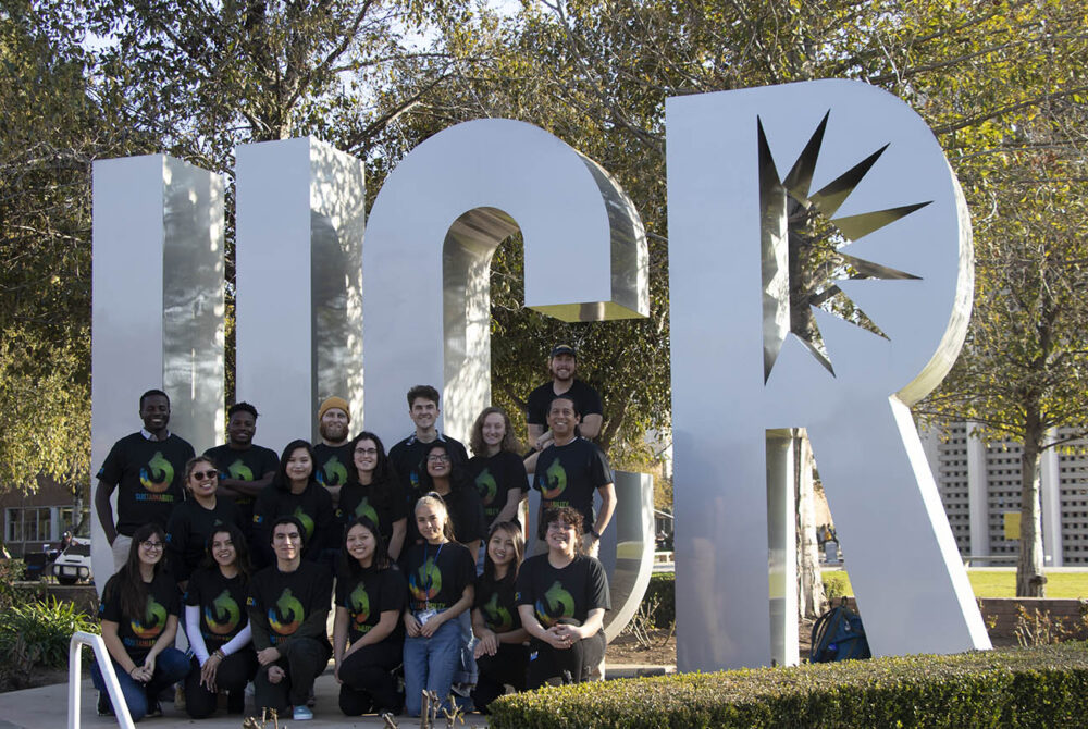 Photo of UC Riverside staff posed in front of a UCR statue