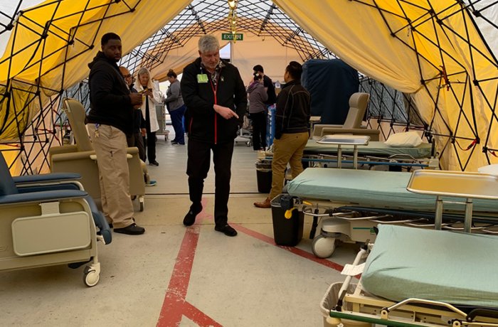 UCSD Health surge tent with empty hospital beds and chairs