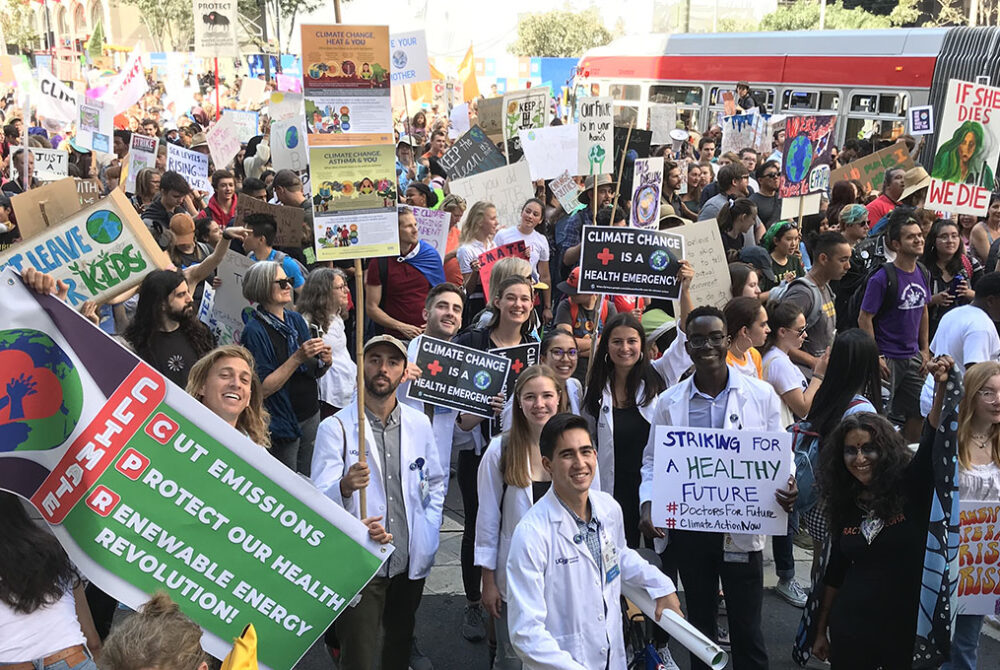 Large group of UCSF medical students holding signs and protesting at an event on climate change