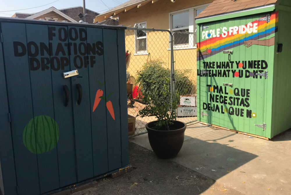 Two outdoor storage sheds housing food donation drop-offs and The People's Fridge