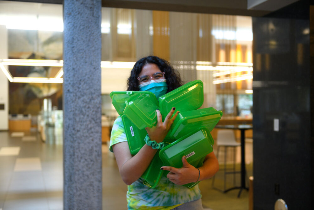 Student wearing a mask carrying reusable food containers