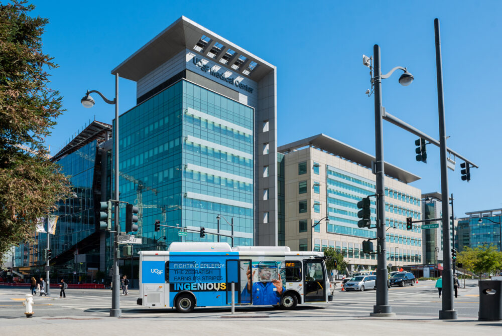 UCSFH Transportation all-electric, zero-emission transit bus driving through the city
