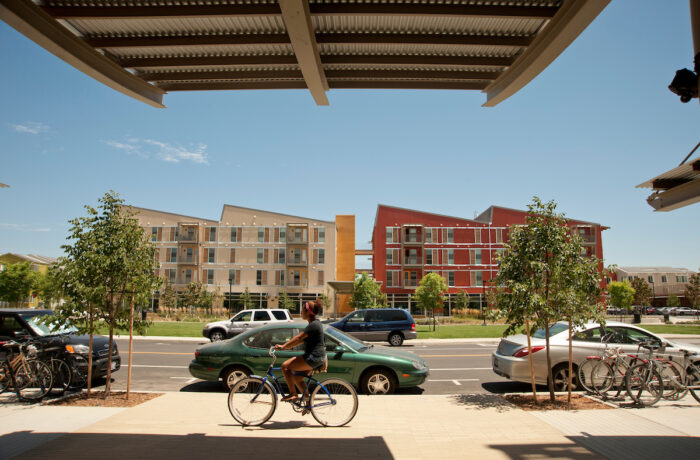 A female riding her bike through West Village at UC Davis