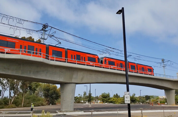 Bright red train moving across bridge