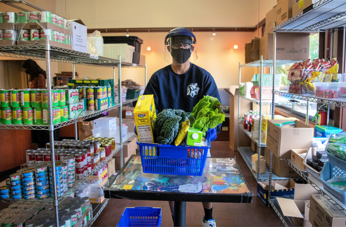 Student wearing mask and face shield participating at Slug Food Pantry