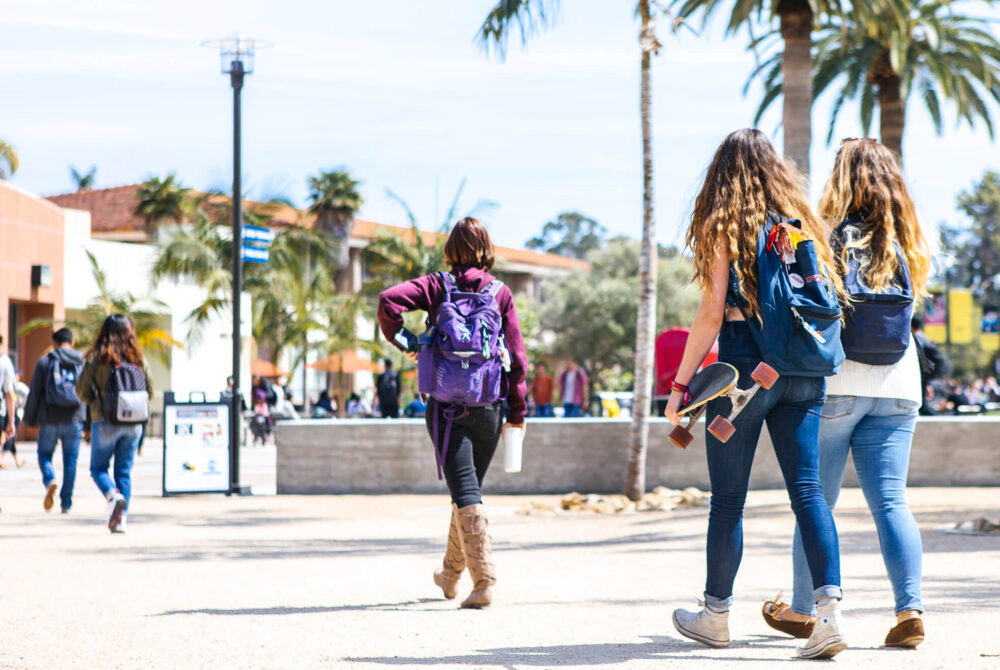 Group of students walking on campus on a bright, sunny day