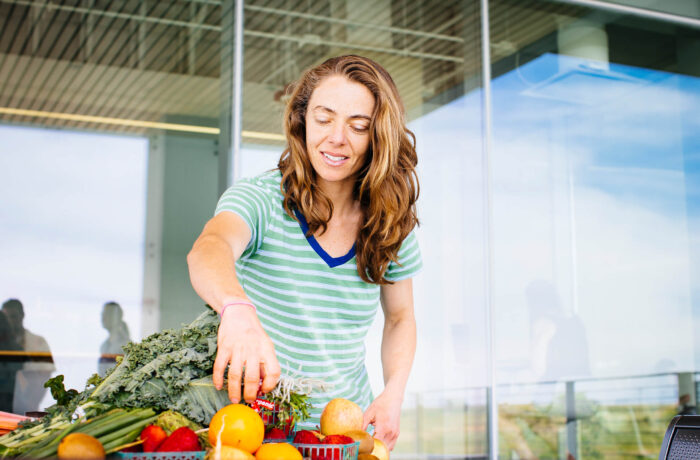 Student organizing fruits and vegetables outside building on campus