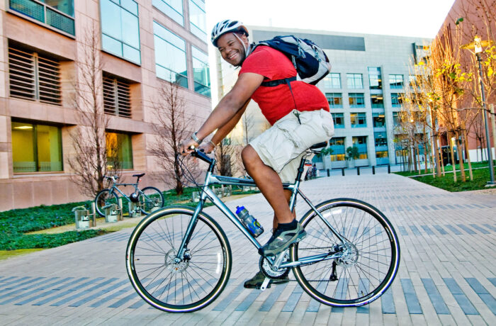 Male student riding bike on campus