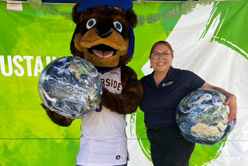 A woman standing beside the UC Riverside mascot