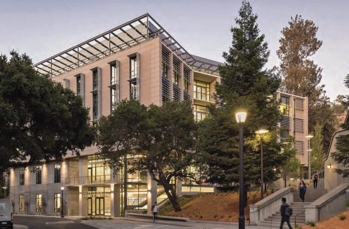 Students walking on campus in front of building