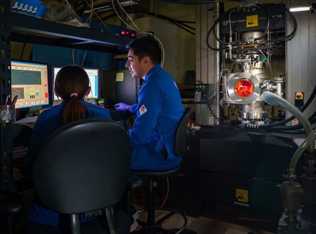 Two people in a laboratory looking at computer monitors