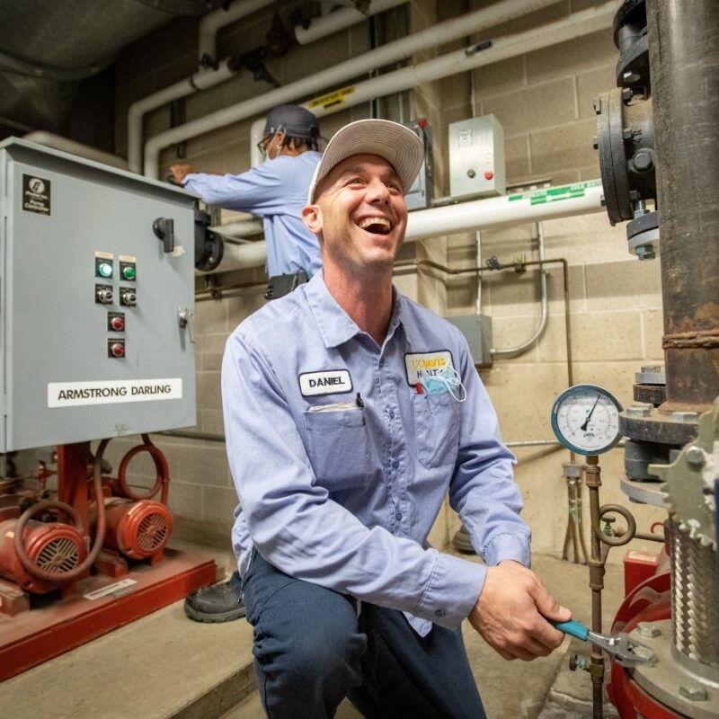 Workers performing maintenance on pipes