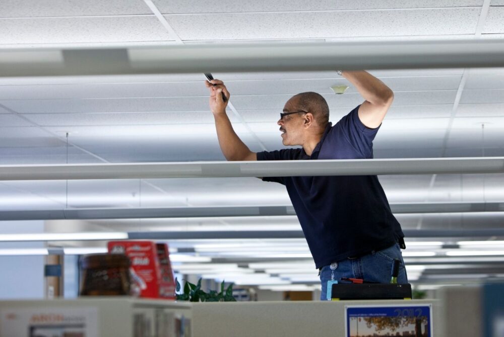 Man performing a repair of the ceiling in an office space